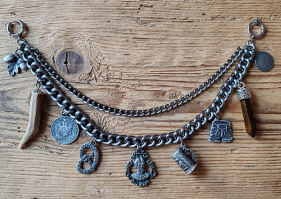 1 Lederhosen-Charivari zweireihig, 9 Anhänger, antik-silberfarben, ca. 33 cm