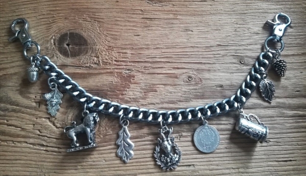 1 Lederhosen-Charivari, 9 Anhänger, antik-silberfarben, ca. 33 cm