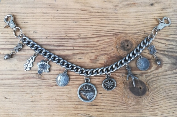 1 Lederhosen-Charivari, 9 Anhänger, antik-silberfarben, ca. 33 cm