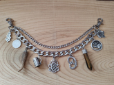 1 Lederhosen-Charivari ,  9 Anhänger, zweireihig, silberfarben, ca. 33cm